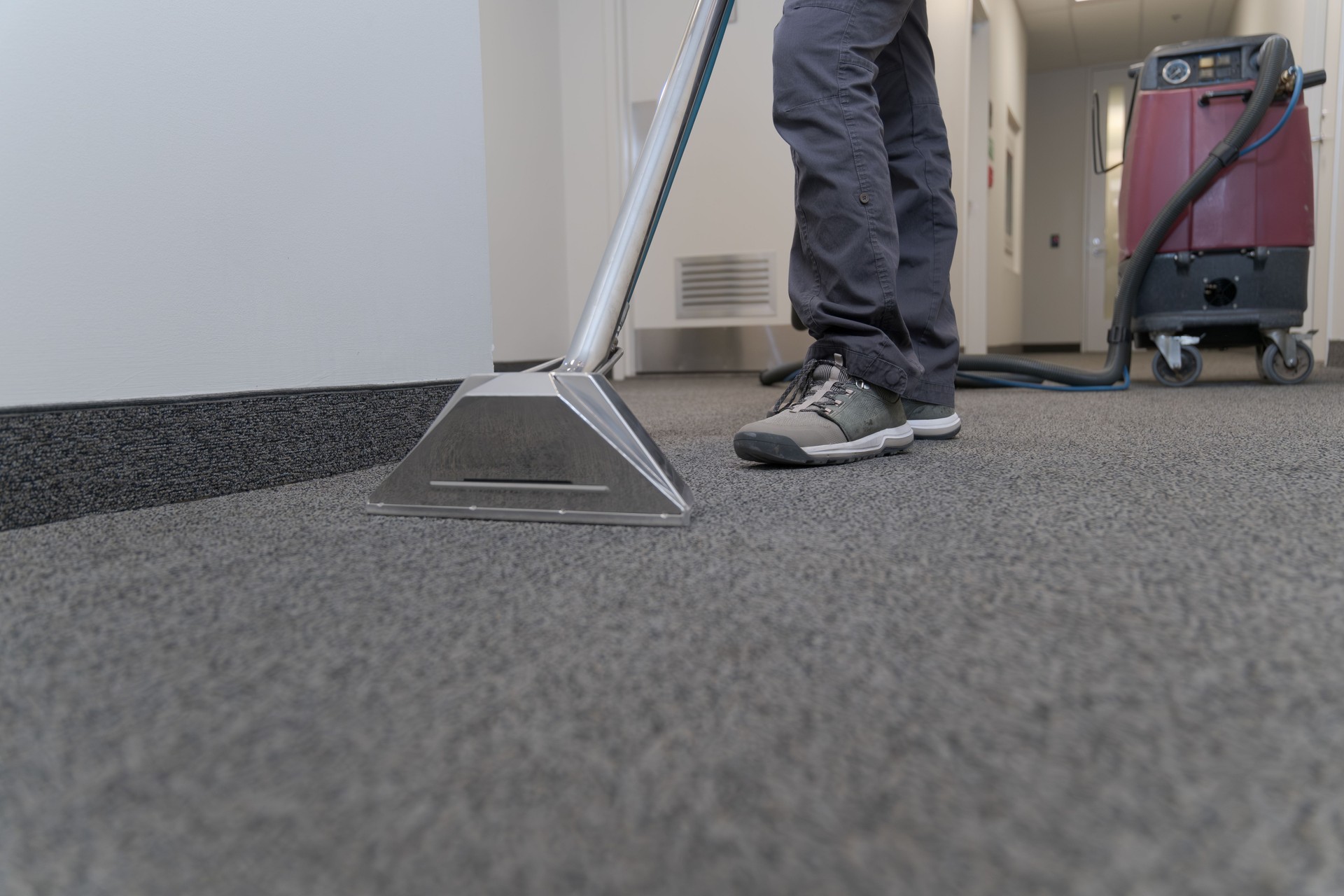 Unrecognizable worker cleaning a carpet with a industrial machine